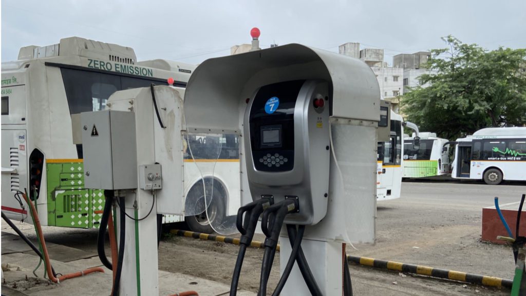 bus charger with zero-emission lettering on bus in background in India